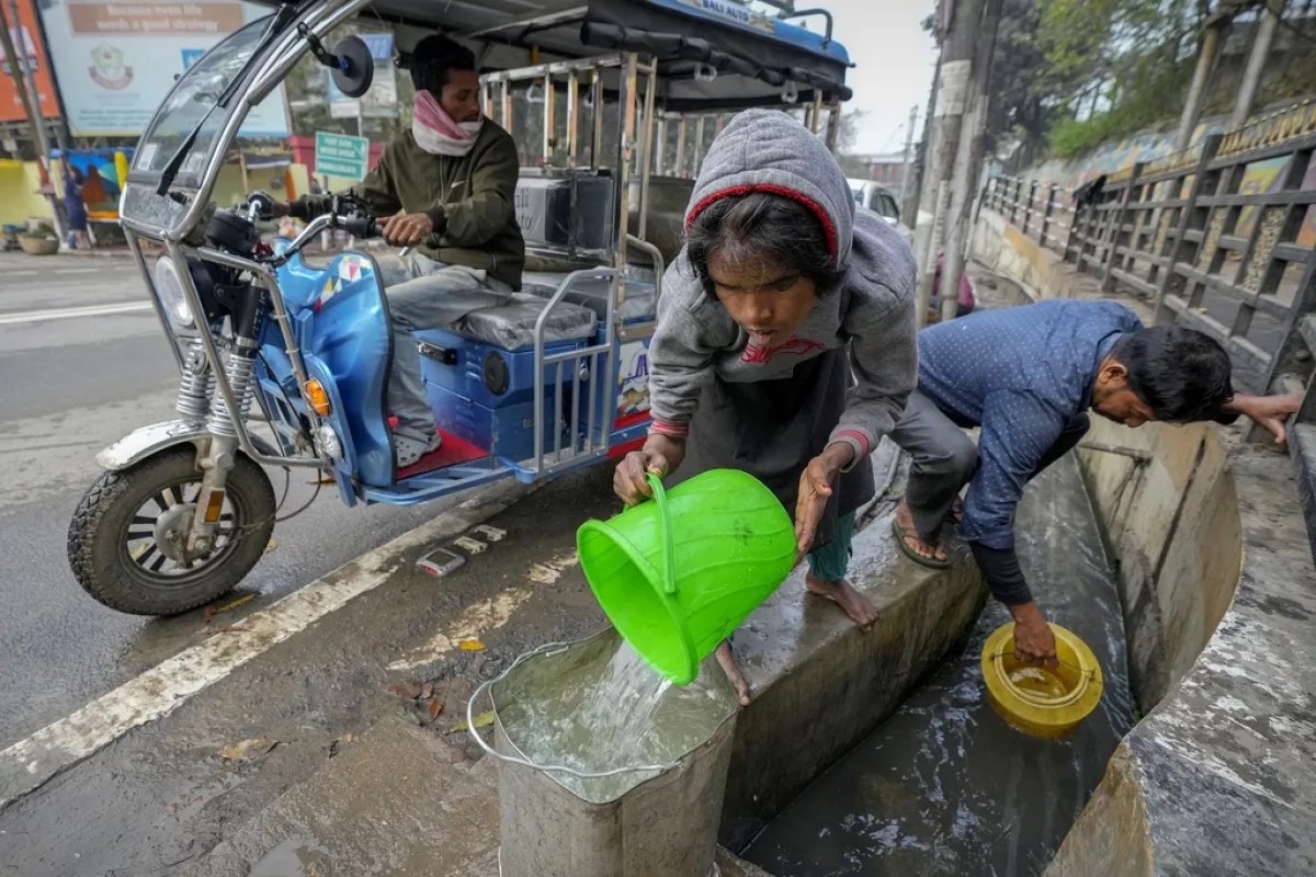 Personas recolectan agua de drenajes debido a la escasez en India. - Foto Anupam Nath/AP